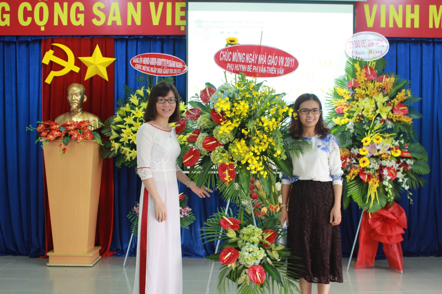 Cô Ánh Minh đại diện nhà trường nhận hoa của phụ huynh chúc mừng